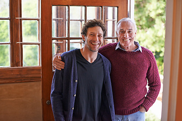 Image showing Son, elderly father and portrait in home by front door with hug, smile and bonding with connection. Men, senior dad and adult child with embrace for love, visit and holiday with pride in family house