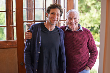 Image showing Son, senior father and portrait in home by front door with hug, smile and bonding with connection. Men, elderly dad and adult child with embrace for love, visit and holiday with pride in family house