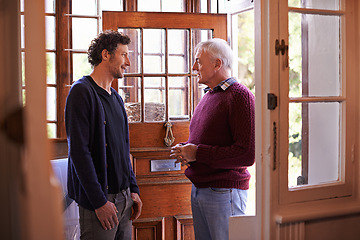 Image showing Son, senior dad and talking in home by front door with advice, chat and bonding with connection. Men, elderly father and adult child with conversation for love, visit and holiday in family house