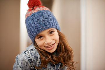 Image showing Girl, portrait and child with fashion in winter at home with pride and confidence in clothes with beanie. Kid, smile or relax in house with hat, jacket or casual style on holiday or vacation