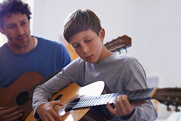 Image showing Learning, guitar and child with teacher for music, lesson and development of skill with instrument. Playing, practice and man helping kid in education as musician mentor in acoustic sound on strings