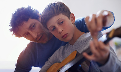 Image showing Learning, music and child with teacher for guitar, lesson and education of skill with instrument. Playing, practice or man training kid in development as musician or mentor in creative study of sound