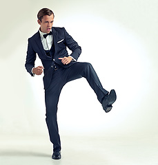 Image showing Businessman, kick and studio confidence in suit or career opportunity with growth goals, white background or mockup space. Male person, leg and classy bowtie as professional for job, formal or event