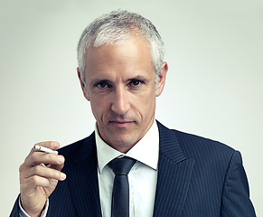 Image showing Portrait, suit and mature man smoking cigarette with salesman in studio isolated on a gray background. Face, fashion and serious businessman with tobacco, ceo or manager in vintage clothes in Canada