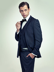 Image showing Fashion, gentleman and tuxedo with cigarette in studio for stylish, trend and habit with suit and luxury. Young person and stare with confidence for vintage, wealthy and handsome for old fashioned