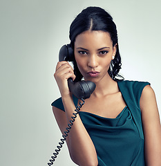 Image showing Portrait, receptionist and business woman on telephone with person pouting in studio isolated on a gray background mockup. Face, landline and secretary on call for communication on retro technology