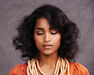 Image showing Indian woman, face and fashion in studio with eyes closed on grey background with beauty and jewelry. Closeup, female person and makeup with traditional necklaces, outfit and heritage look.