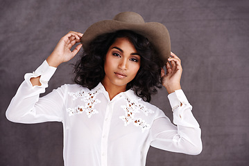 Image showing Portrait, studio and woman with cowboy fashion, confidence and relax with girl in stetson hat. Rodeo, western style and face Mexican model with cowgirl culture, wild west clothes and grey background