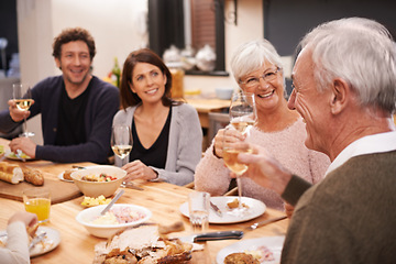 Image showing Happy, cheers and family at supper in dining room for party, celebration or event at modern home. Smile, bonding and people enjoying meal, dinner or lunch together with wine for toast at house.
