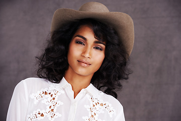 Image showing Portrait, studio and woman with cowgirl fashion, confidence and relax with girl in stetson hat. Rodeo, western style and face Mexican model with cowboy culture, wild west clothes and grey background