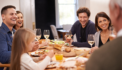 Image showing Happy, conversation and family at dinner in dining room for party, celebration or event at modern home. Smile, bonding and group of people enjoying meal, supper or lunch together with wine at house.