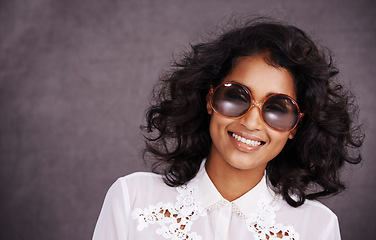 Image showing Studio, smile and fashion for portrait of woman with sunglasses and confidence for Indian girl. Dark background, adult and female person with unique style, relax and aesthetic for proud model