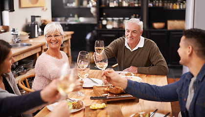Image showing Cheers, wine and family at dinner in dining room for party, celebration or event at modern home. Smile, bonding and group of people enjoying meal, supper or lunch together with champagne at house.