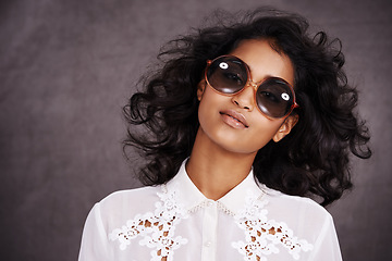 Image showing Studio, boho and fashion for portrait of woman with sunglasses and confidence for Indian girl. Dark background, adult and female person with unique style, relax and aesthetic for proud model