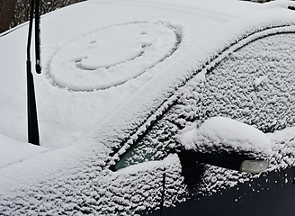 Image showing A snow covered car with a smiley face on it