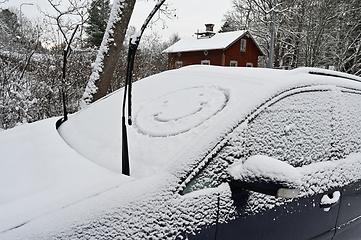 Image showing A snow covered car with a smiley face on it