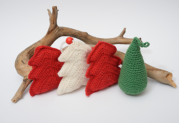 Image showing A group of knitted christmas trees and a piece of wood