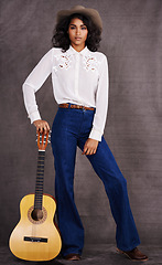 Image showing Woman, fashion and musician cowgirl in studio, western clothing and guitar with confidence. Native American, female person in serious portrait for trendy countryside culture, isolated on background