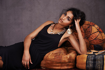 Image showing Fashion, studio and portrait of woman on sofa with Mexican style, relax and confidence in makeup. Model, cosmetics and latino girl on couch with glamour, elegance and jewellery on grey background