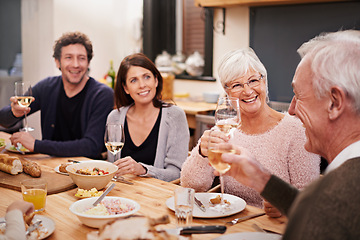 Image showing Smile, cheers and family at dinner in dining room for party, celebration or event at modern home. Happy, bonding and group of people enjoying meal, supper or lunch together with wine at house.