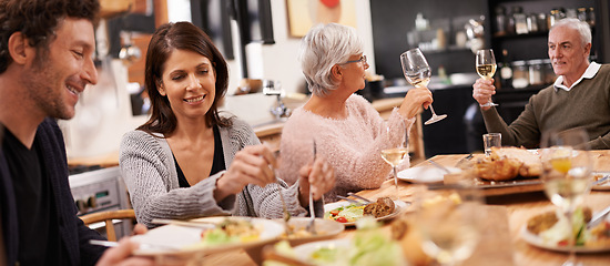 Image showing Cheers, eating and family at dinner in dining room for party, celebration or event at modern home. Smile, bonding and people enjoying meal, supper or lunch together with wine for toast at house.