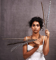 Image showing Fashion, studio and portrait of boho woman with feather, mockup and modern Native American style. Creative, culture and girl with indigenous aesthetic, serious or unique face on grey background space