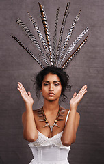 Image showing Indian woman, fashion and feathers with jewelry in studio on black background for heritage or culture. Portrait, female person and confident with traditional necklaces or accessory and hands up