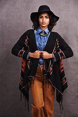 Image showing Fashion, cowgirl or woman with confidence in portrait, studio or cool clothing in culture on grey background. Native American person, unique or stylish model with pride, boho style or western poncho