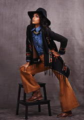 Image showing Culture, cowgirl or woman thinking in studio, wild west and cool fashion or clothing on grey background. Native American person, western lady and stylish model with pride, boho style and chair stool