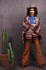 Image showing Cactus, fashion or cowgirl in style, portrait, wild west culture or cool clothes in studio on grey background. Confident person, western woman or stylish model with pride, boho outfit or plants