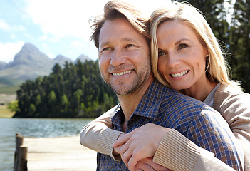 Image showing Lake, smile and couple by forest in summer for weekend adventure, holiday and happiness outdoors. Man, woman and embrace with love in nature for vacation, travel and tourism together in Europe