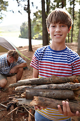 Image showing Boy, dad and camping with firewood in portrait for heat, cooking and learning on outdoor adventure. Child, father and wood in forest for holiday, vacation and happy in nature by trees in Colorado