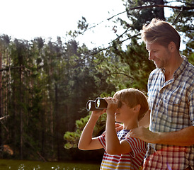 Image showing Nature, man and son with binoculars in forest for sightseeing, summer vacation and exploring environment. Smile, kid and dad with field glasses for vision, happiness and tourism together in Europe