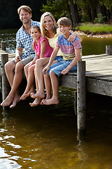 Image showing Parents, lake and kids on pier for portrait, hug and happy on vacation, relax or love in summer sunshine. Mom, dad and children with smile, care or bonding with family by river on holiday in Colorado