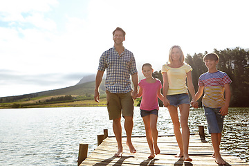 Image showing Family, children and pier by lake for holding hands in portrait, happy or vacation with love in summer sunshine. Mom, dad and kids with smile, care or bonding on walk by river for holiday in Colorado