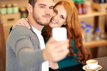 Image showing Couple, coffee and selfie with smartphone in cafe, man and woman together with smile. Happy people, romantic and dating in relationship with affection, mobile and photography for social media post