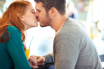 Image showing Couple, date and kiss with romance, coffee shop or restaurant with happiness together. Man, woman and love for relationship, care and smile for flirting on break for relax or bonding in cafe