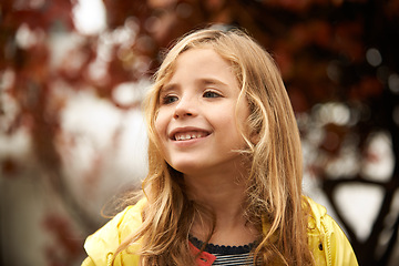 Image showing Smile, thinking and happy girl in autumn, winter and outdoors for cold weather. Face, child and joyful in winter season or rain on vacation in Scotland, holiday or outside for freedom or travel
