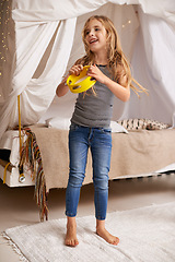 Image showing Girl, child and happy in home with tambourine for playing, music or learning rhythm in bedroom. Kid, instrument and smile for noise, sound and laughing for funny games with creativity at family house
