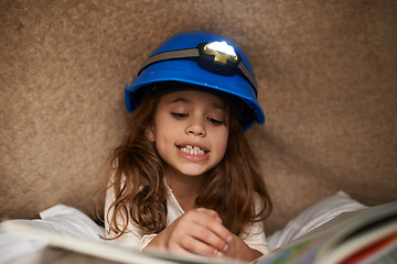 Image showing Girl, child and book with headlamp for reading, above and learning with smile for education in family home. Kid, story and happy with light for info, language and literacy skills on floor in house
