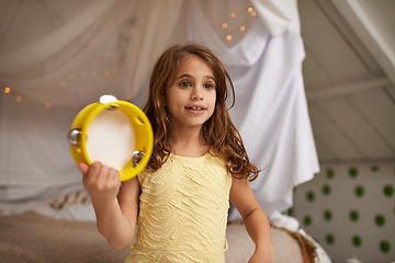 Image showing Girl, child and happy in house with tambourine for playing, music and learning rhythm in bedroom. Kid, instrument and smile for noise, sound and concert for funny games with creativity at family home