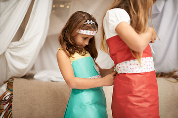 Image showing Children, play and costume for dress, game and fun in house with wrapping for bonding and creative. Sibling, sister or kid for friendship, help and clothes for childhood, innocent and adorable