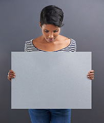 Image showing Woman, presentation and advertising with billboard for marketing on a gray studio background. Young female person or Indian holding poster or sign for notification, alert or message on mockup space