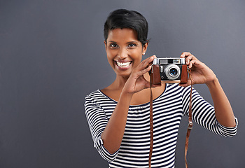 Image showing Woman, smile and portrait with camera for picture, photographer and lens in studio for capture on mockup. Indian person and happy for retro, vintage and shot for pose, angle and zoom indoor