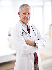 Image showing Portrait, medicine and doctor man with arms crossed in hospital for support, services and wellness. Healthcare, lens flare and happy mature medical professional for confident, smile and treatment
