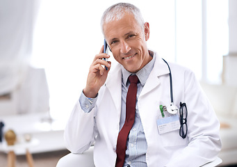 Image showing Doctor, man and call with smartphone in hospital for Consultation, conversation or healthcare results. Clinic, smile and mature medic by mobile for communication, discussion or medical insurance