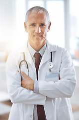 Image showing Healthcare, portrait and doctor with arms crossed in hospital for support, services and wellness. Medicine, lens flare and happy mature medical professional for confident, help and treatment