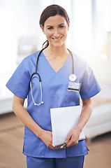 Image showing Portrait, nurse and happy woman in hospital with document for healthcare, wellness or career in Spain. Smile, medical professional and surgeon with paperwork, employee or expert doctor in clinic