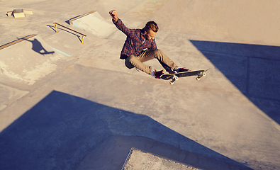 Image showing Man, hobby and skateboard at skatepark for practice or training to play, trick and committed. Outdoor, exercise and experience on break or leisure to enjoy for activity, sport and passion for fitness