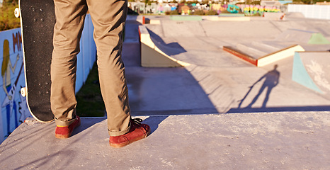 Image showing Man, legs and skateboard for hobby at skatepark with practice or training to play, trick and committed. Closeup, exercise and experience on break or leisure to enjoy for activity, sport and fitness